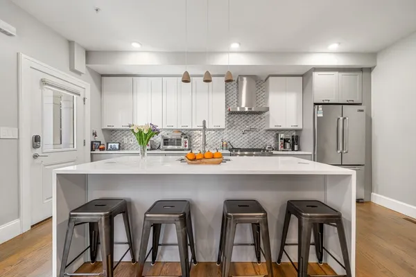 a kitchen with a table chairs refrigerator and cabinets