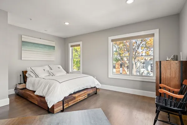 a bedroom with a bed flat screen tv and windows
