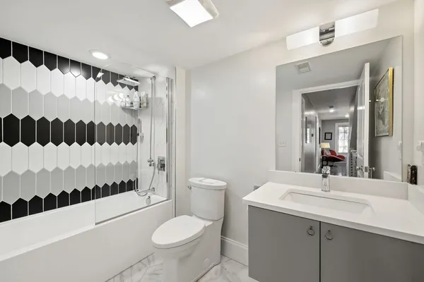 a bathroom with a sink toilet a mirror a vanity and shower