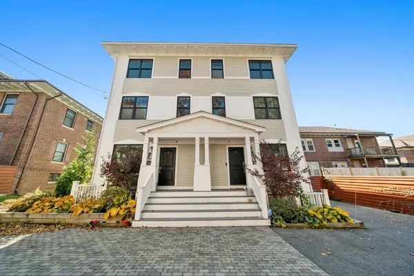 a view of a white building among the front of a house
