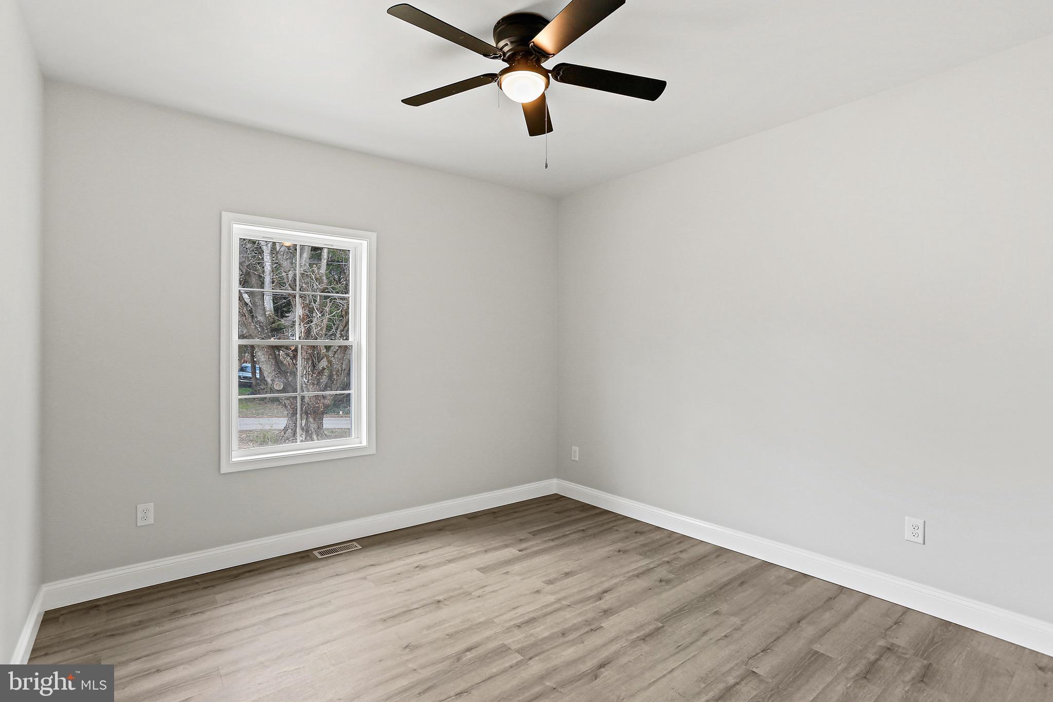 23 Juniper Road Delta, PA 17314 - Photo 11 of 33 an empty room with wooden floor ceiling fan and windows
