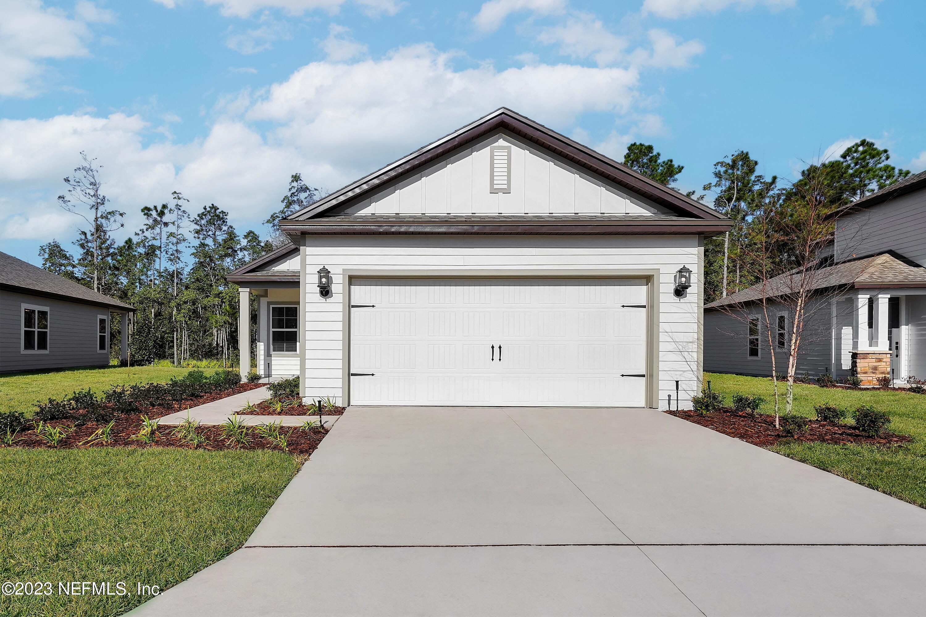 654 Morgans Treasure Road St. Augustine, FL 32084 - Photo 2 of 8 a front view of a house with a yard and garage