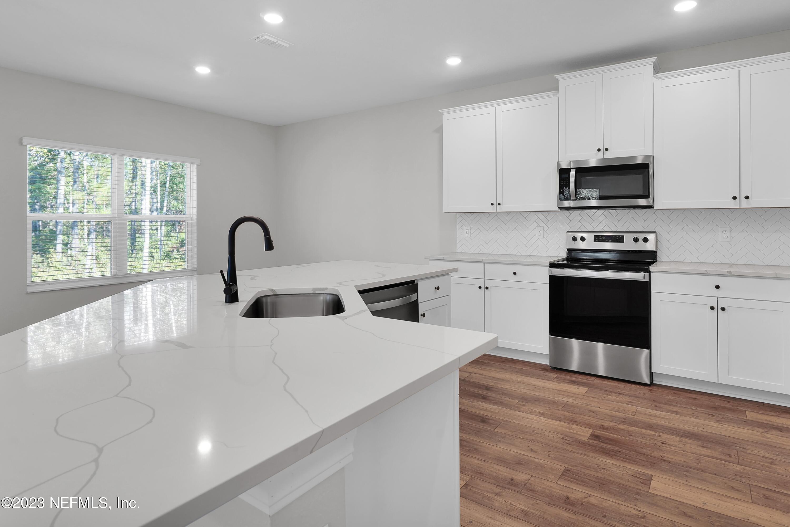 654 Morgans Treasure Road St. Augustine, FL 32084 - Photo 4 of 8 a kitchen with a stove a sink and a microwave