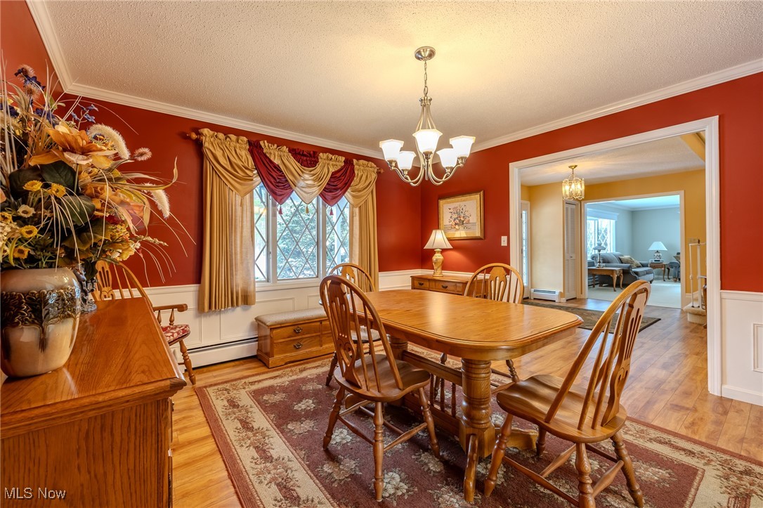 535 Barrington Ridge Road Painesville, OH 44077 - Photo 16 of 48 Dining room with wood-type flooring, ornamental molding, a textured ceiling, and an inviting chandelier
