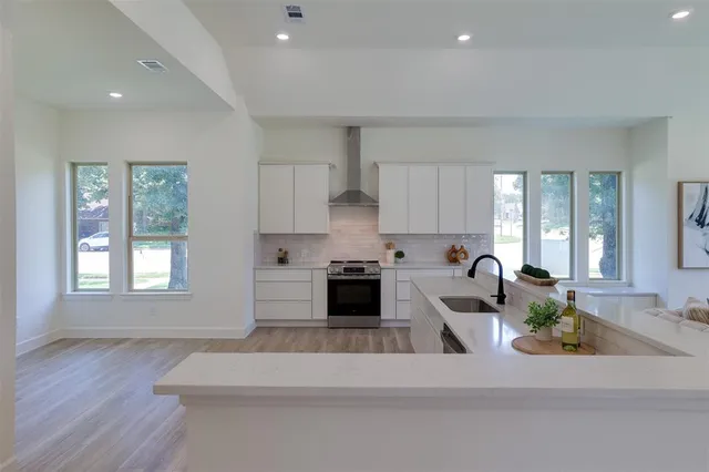 a kitchen with a white cabinets and stove top oven