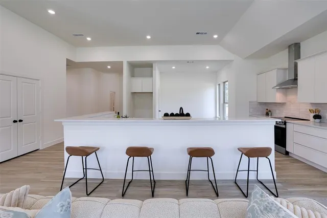 a kitchen with stainless steel appliances kitchen island a table and chairs in it