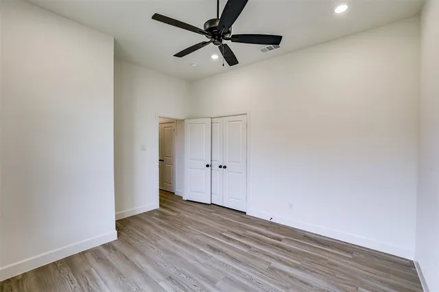 a view of a livingroom with wooden floor and a ceiling fan