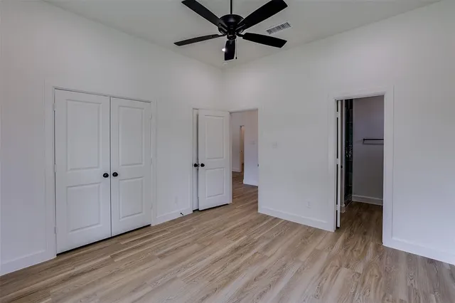 a view of a room with wooden floor and a ceiling fan