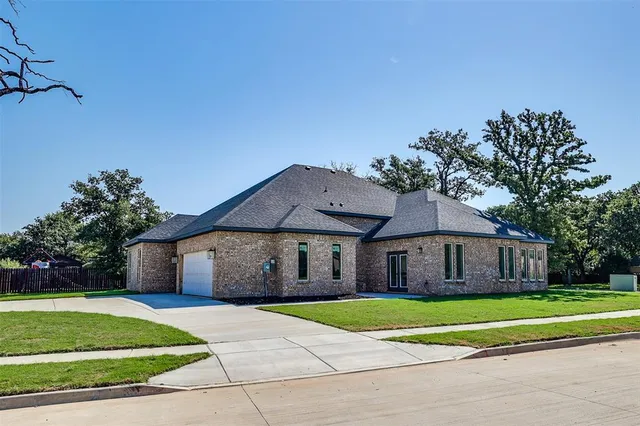 a front view of a house with a yard and trees