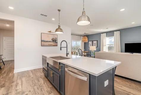 a large kitchen with kitchen island a stove a sink a refrigerator and a dining table with wooden floor