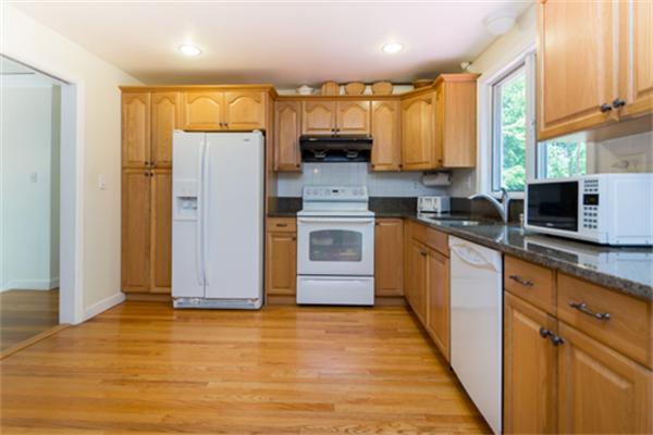 930 Central Avenue Needham, MA 02492 - Photo 7 of 21 a kitchen with stainless steel appliances granite countertop a refrigerator a sink dishwasher a stove with wooden cabinets and floor
