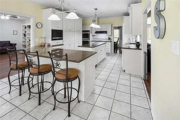 a kitchen with stainless steel appliances granite countertop a stove a sink and a white cabinets