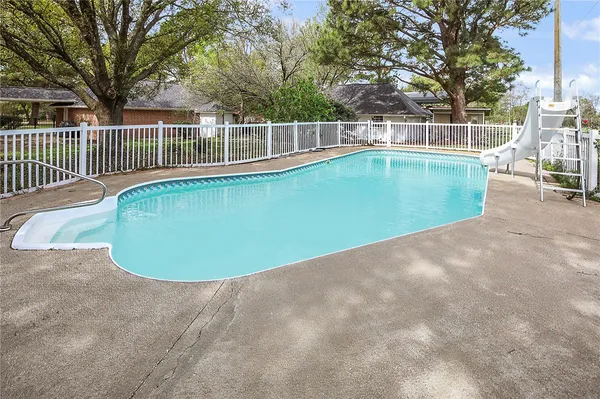 a view of a swimming pool with a patio and yard