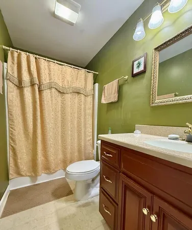 a bathroom with a granite countertop sink a toilet and a mirror