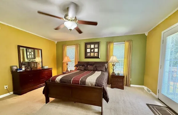 a bedroom with a bed and dresser with mirror