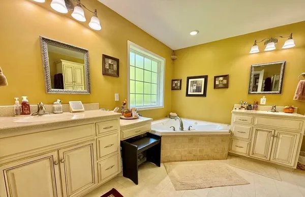a bathroom with a tub sink and mirror