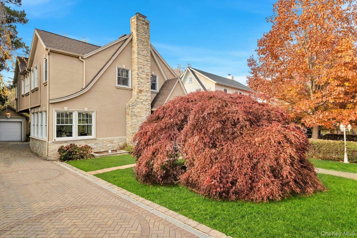 193 Nelson Road Scarsdale, NY 10583 - Photo 2 of 37 a front view of a house with a garden