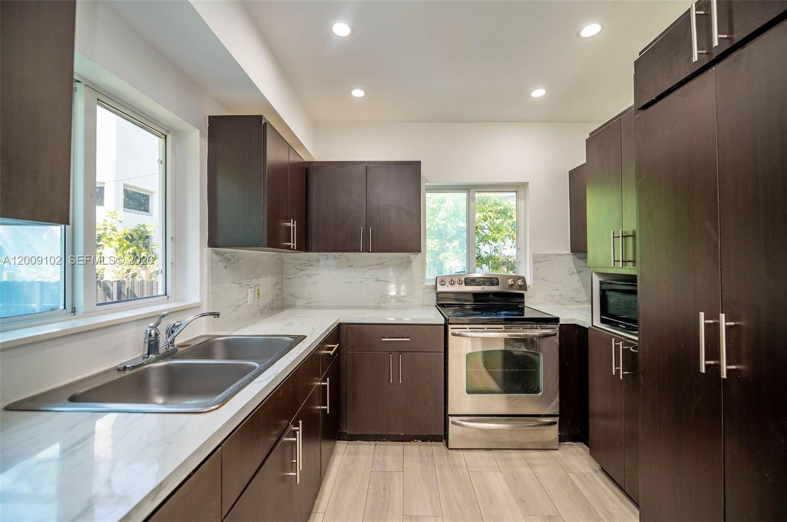 330 Southwest 27th Road Miami, FL 33129 - Photo 11 of 62 a kitchen with a sink stove and cabinets