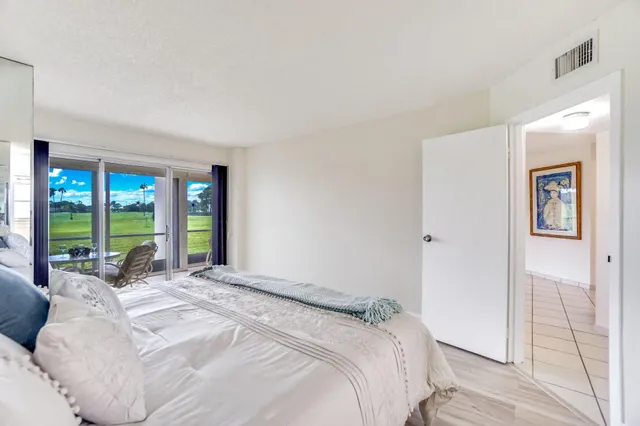 a bed sitting in a spacious bedroom next to a window