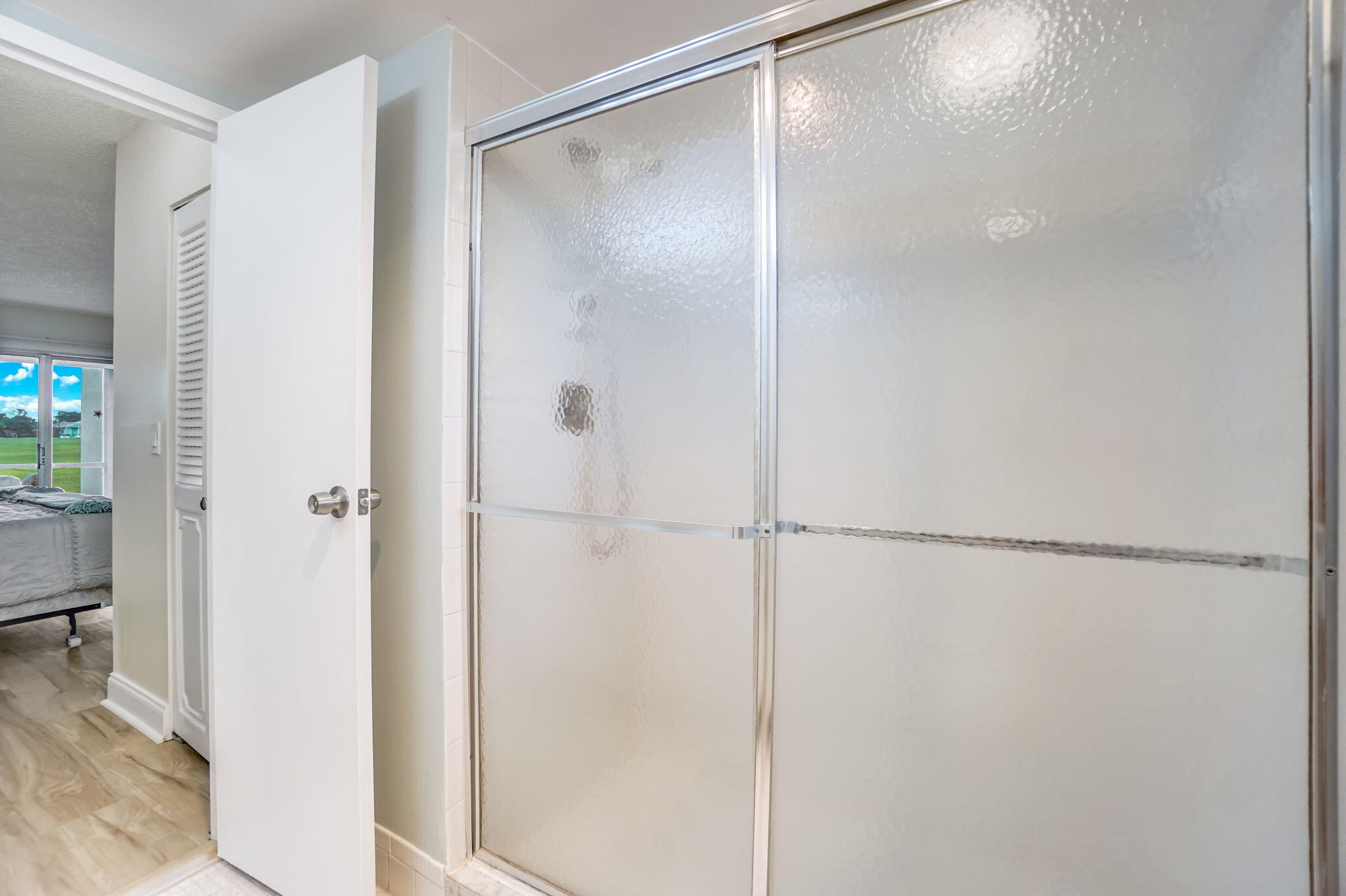 3951 Via Poinciana, Unit 114 Lake Worth, FL 33467 - Photo 17 of 34 a bathroom with a glass shower door