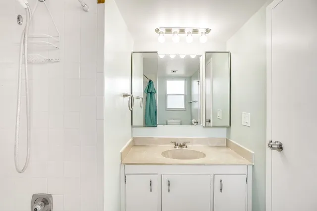 a bathroom with a granite countertop sink and a mirror