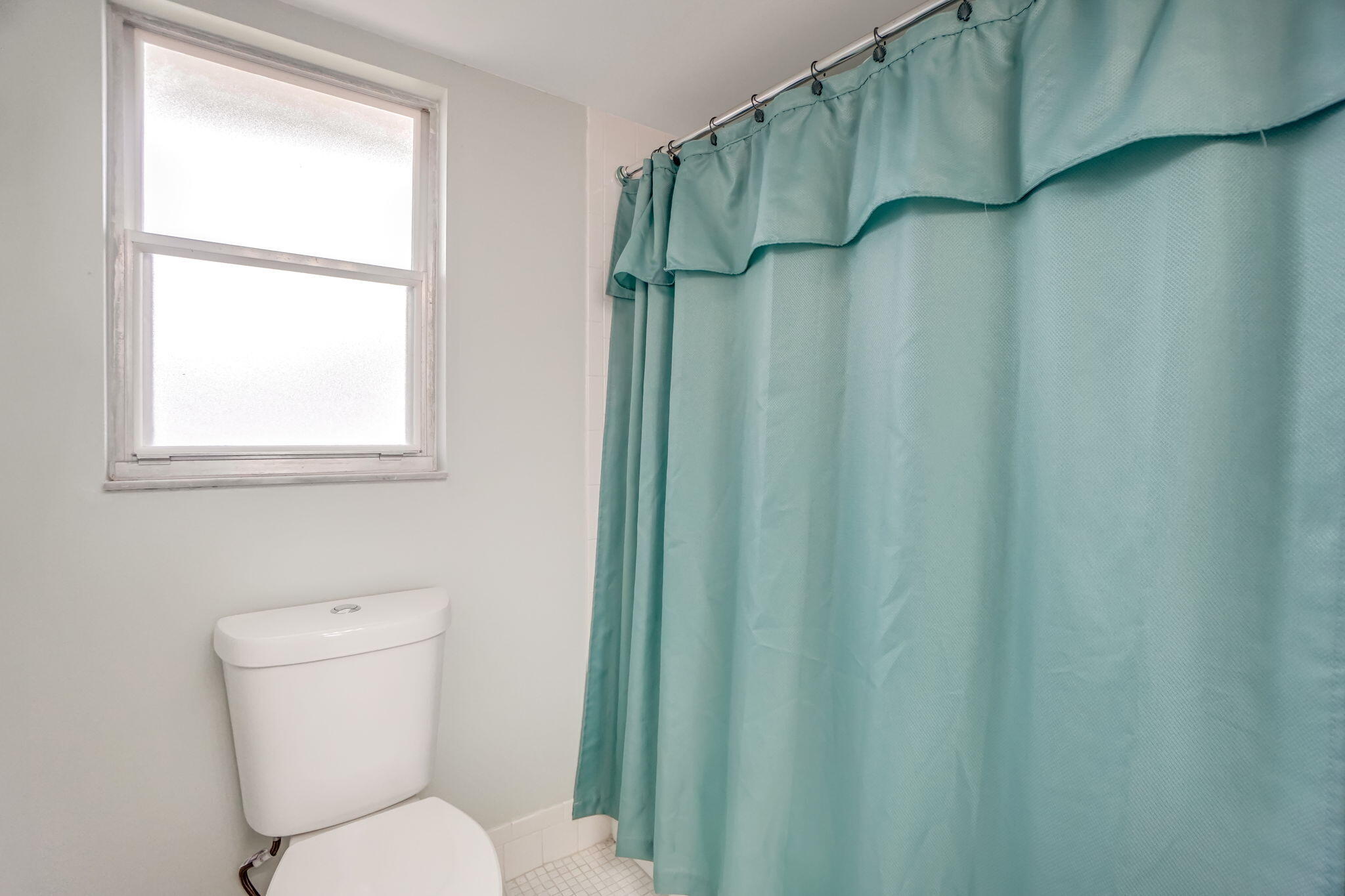 3951 Via Poinciana, Unit 114 Lake Worth, FL 33467 - Photo 21 of 34 a white toilet sitting next to a shower curtain