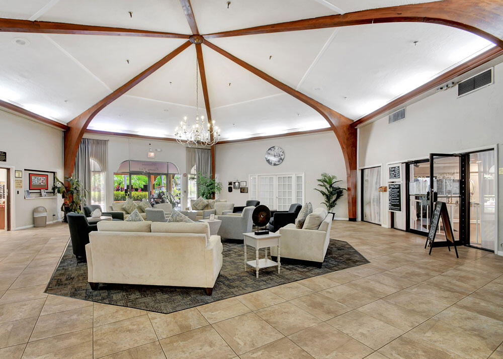 3951 Via Poinciana, Unit 114 Lake Worth, FL 33467 - Photo 31 of 34 a living room with furniture and a chandelier