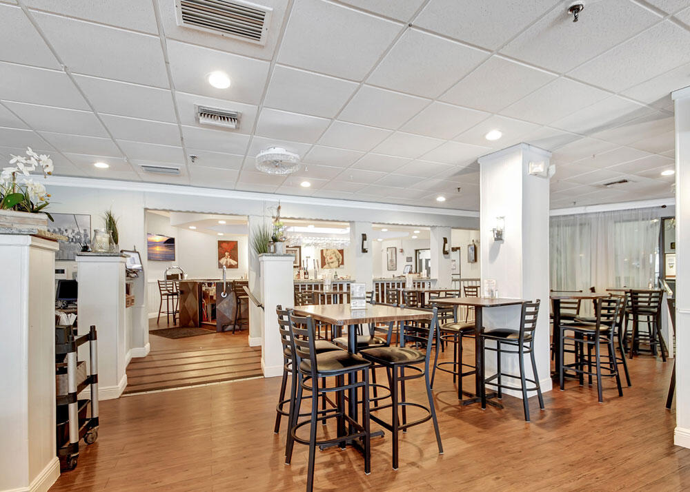 3951 Via Poinciana, Unit 114 Lake Worth, FL 33467 - Photo 32 of 34 a view of a dining hall with lots of furniture and windows