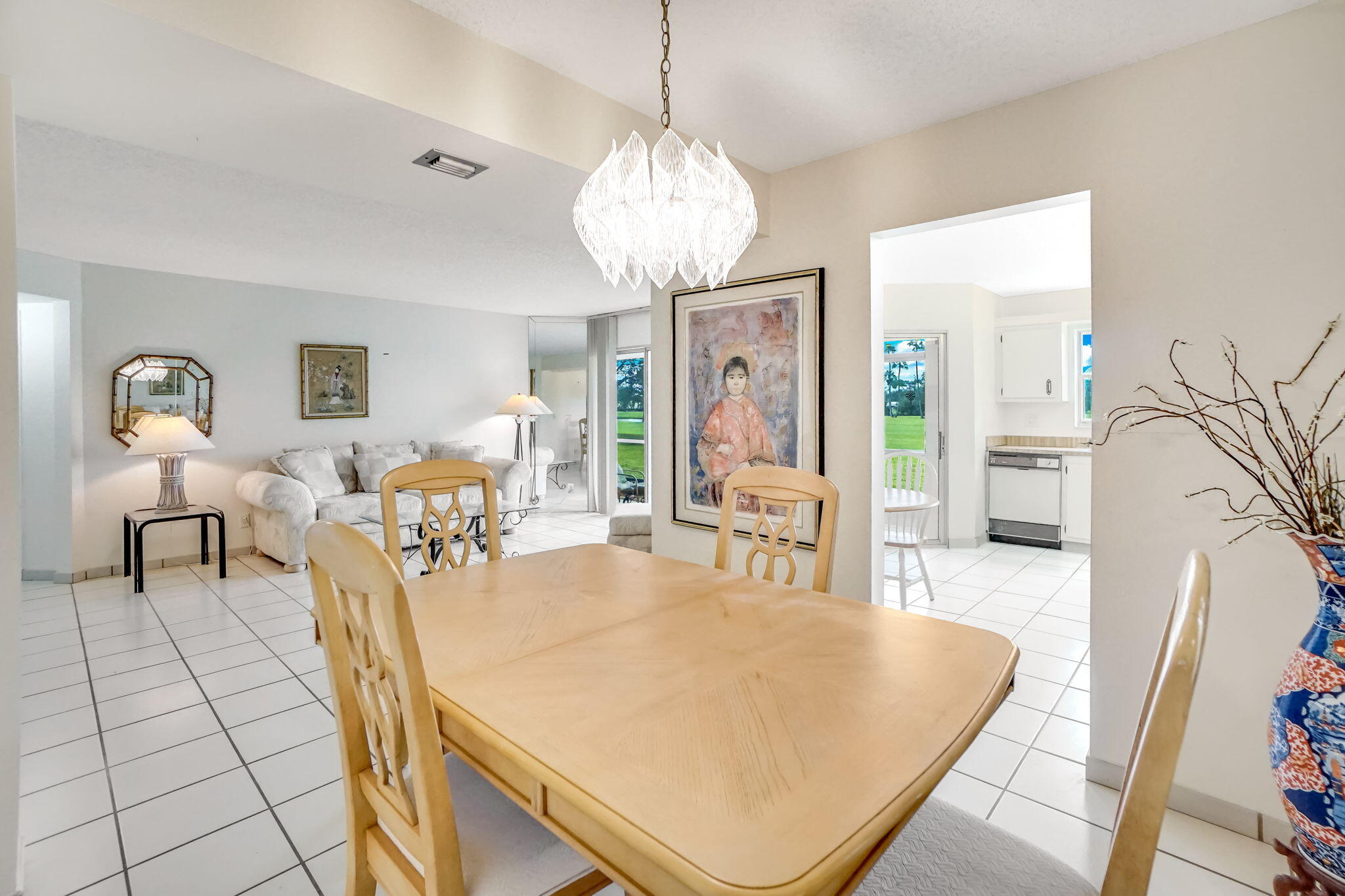 3951 Via Poinciana, Unit 114 Lake Worth, FL 33467 - Photo 7 of 34 a living room with furniture a chandelier and a dining table