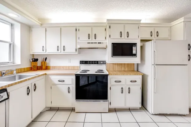 a kitchen with a stove top oven sink and cabinets