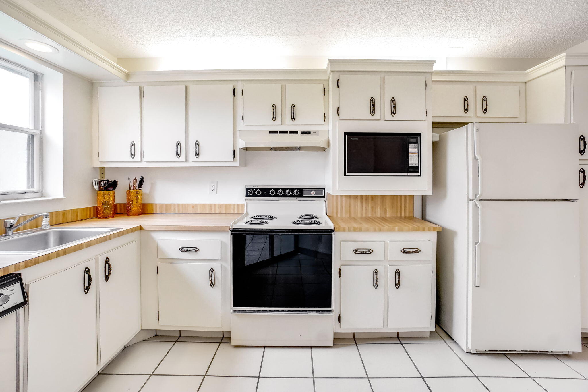 3951 Via Poinciana, Unit 114 Lake Worth, FL 33467 - Photo 8 of 34 a kitchen with a stove top oven sink and cabinets