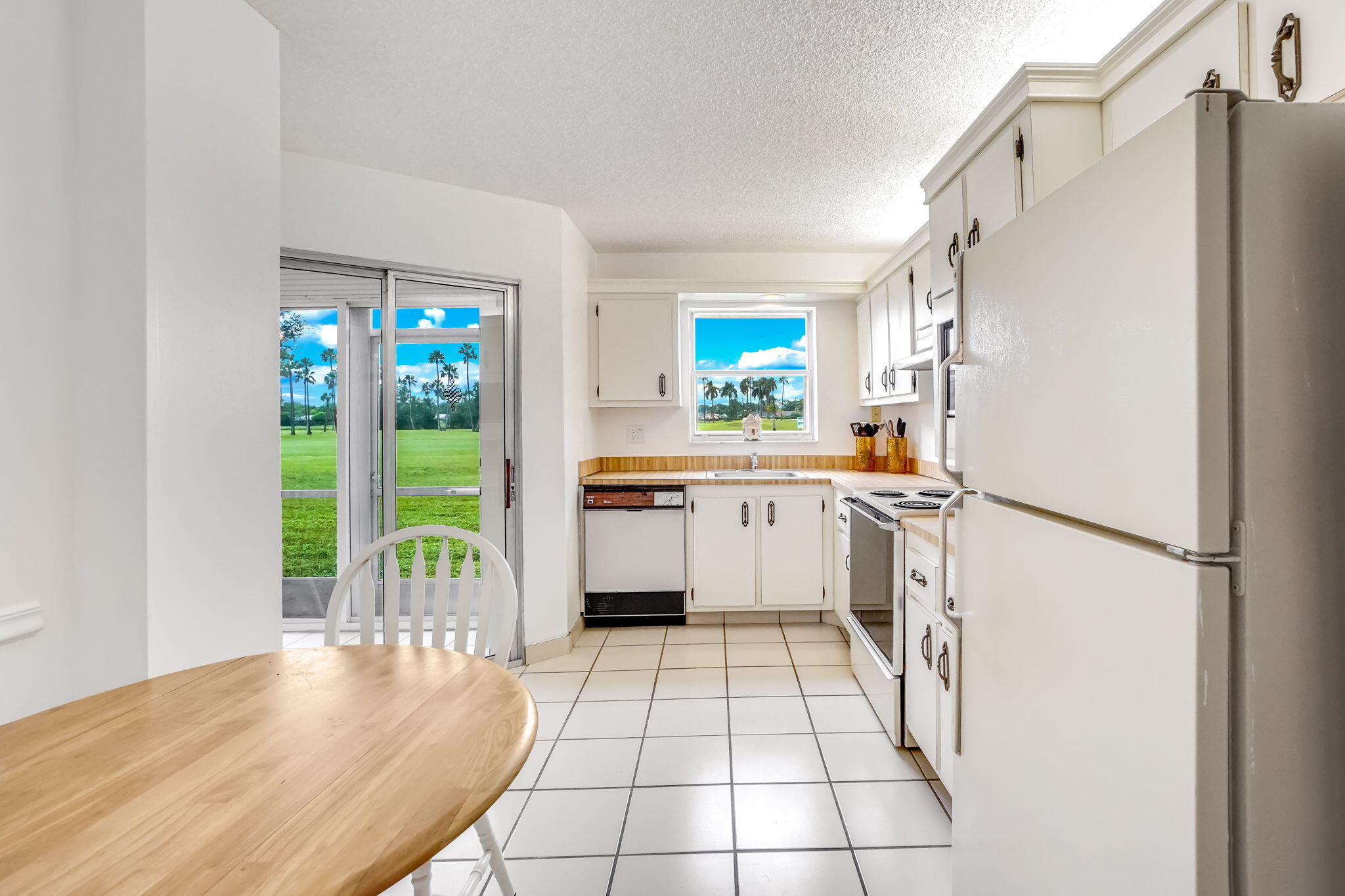3951 Via Poinciana, Unit 114 Lake Worth, FL 33467 - Photo 9 of 34 a kitchen with a refrigerator a stove top oven and a window
