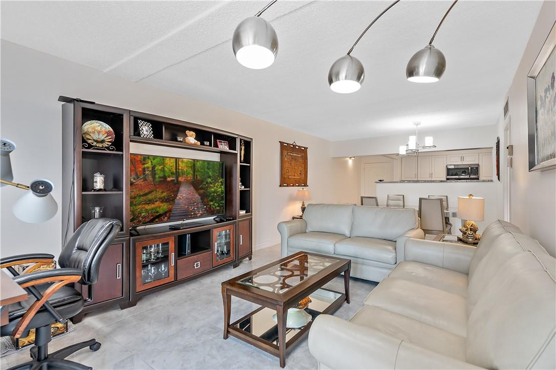 95 North Birch Road, Unit 405 Fort Lauderdale, FL 33304 - Photo 17 of 34 a living room with furniture a flat screen tv and kitchen view