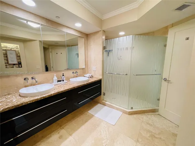 a bathroom with a double vanity sink mirror and shower