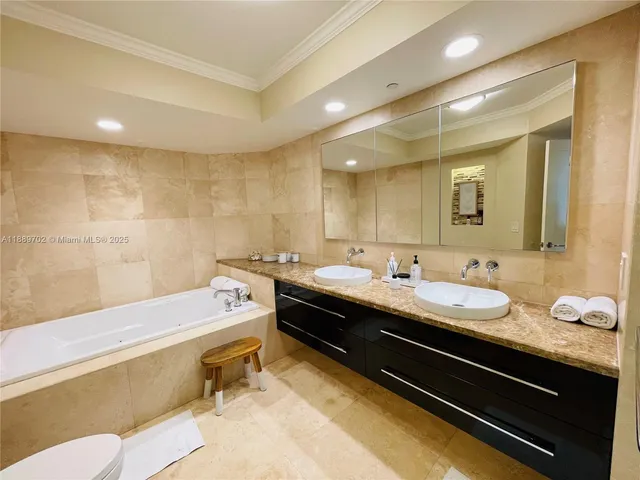 a bathroom with a granite countertop sink a large mirror and a bathtub