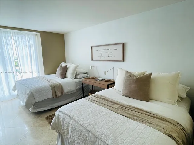 a bedroom with two beds and a window