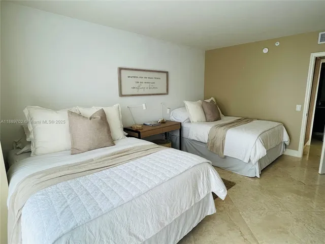 a bedroom with two beds and painting on the wall