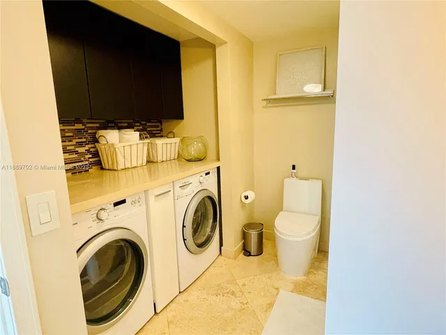 a view of a bathroom with washing machine and a flat screen tv