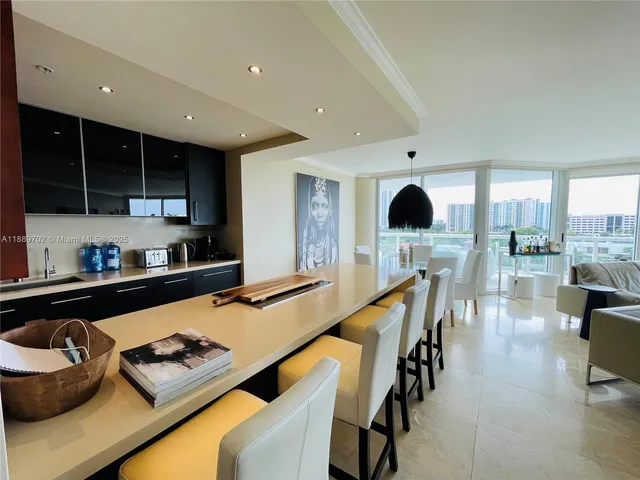 a kitchen with stainless steel appliances granite countertop a stove top oven a sink a dining table and chairs with wooden floor