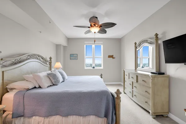 a bedroom with a large bed and a flat tv screen on dresser