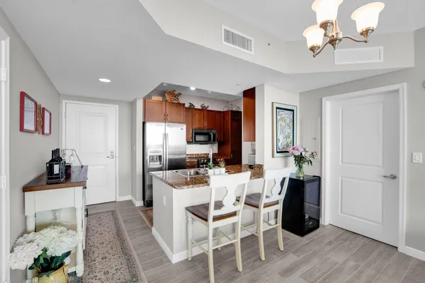 a dining room with wooden floor a chandelier fan a wooden table and chairs