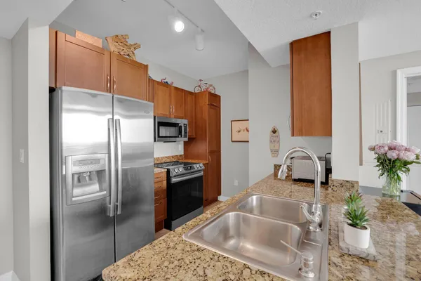 a kitchen with granite countertop a refrigerator and a sink