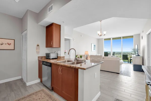 a view of kitchen with stainless steel appliances granite countertop a sink a stove and wooden floor