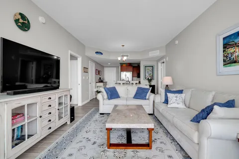 a bedroom with a bed a chandelier and a flat screen tv