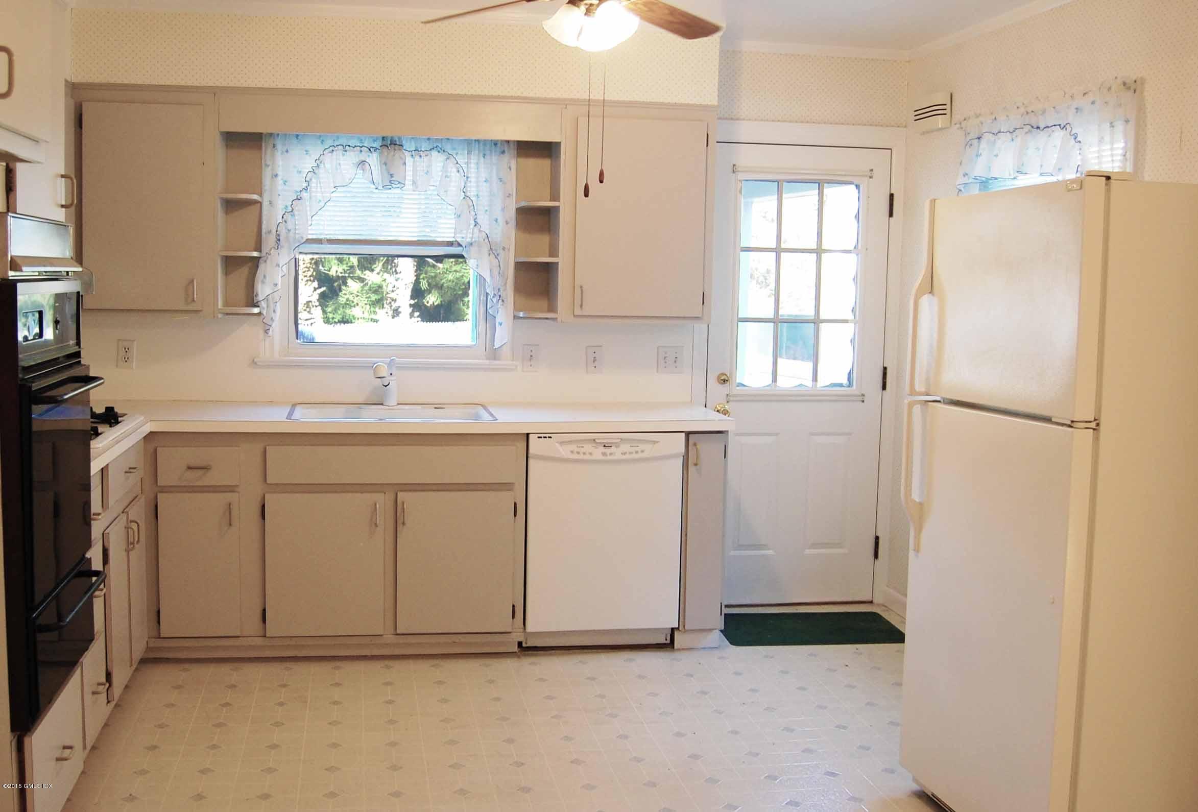 55 Sound Beach Ave Extension Riverside, CT 06878 - Photo 2 of 9 a kitchen with white cabinets and window