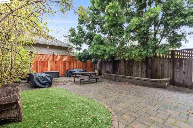 a view of a chair and table in backyard of the house