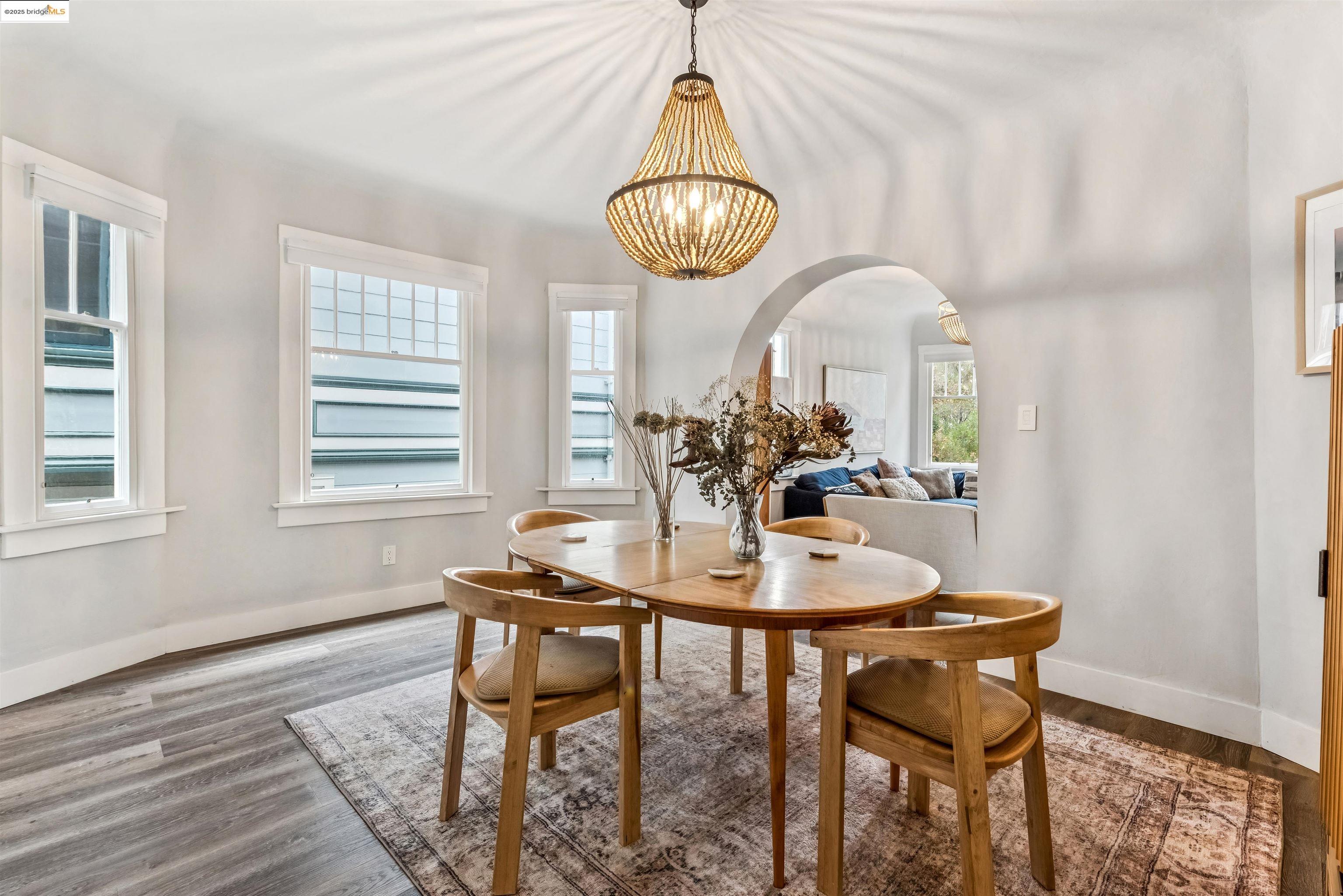 1254 Broadway Alameda, CA 94501 - Photo 5 of 12 Dining space featuring arched walkways, wood finished floors, and a chandelier