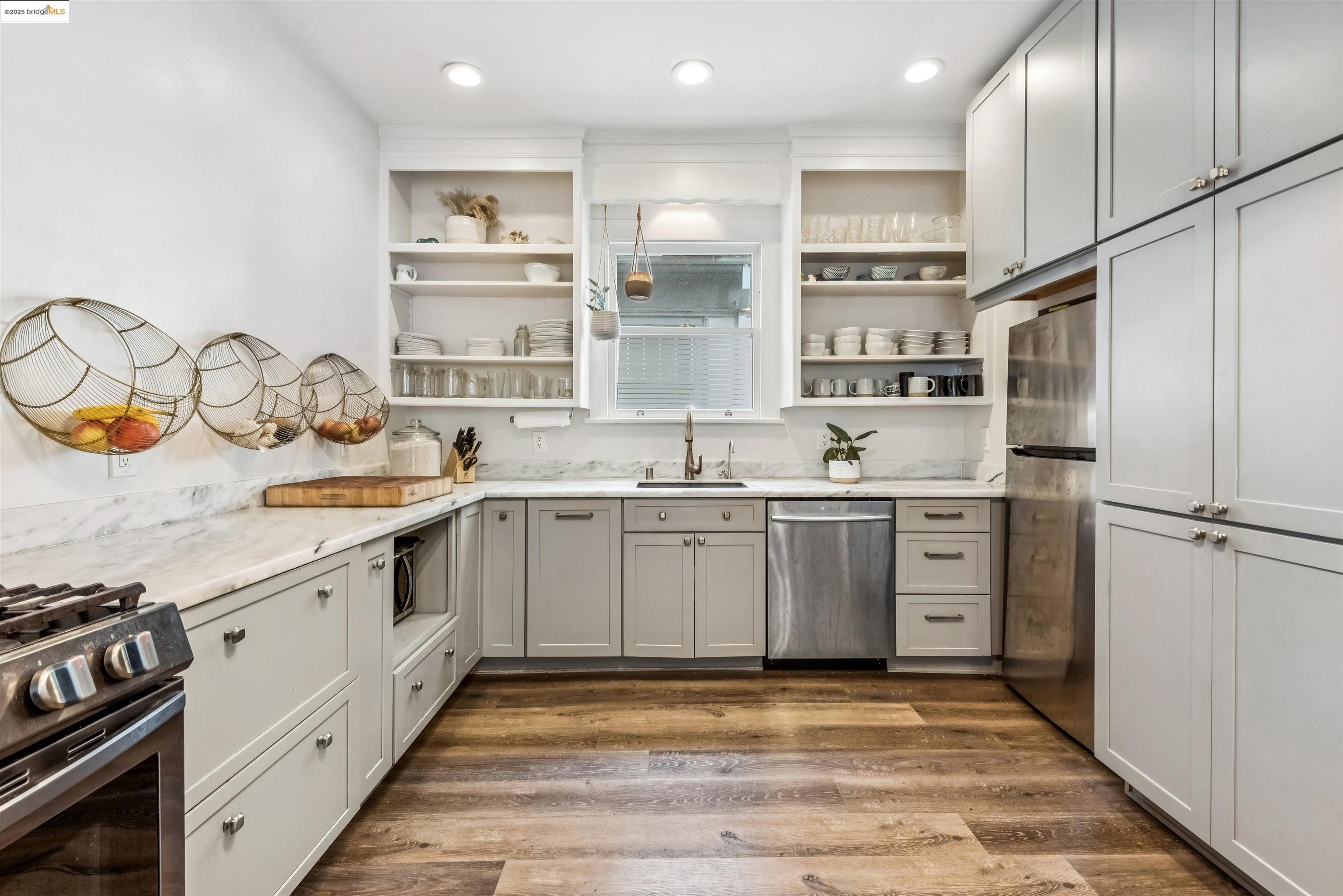 1254 Broadway Alameda, CA 94501 - Photo 7 of 12 Kitchen with open shelves, stainless steel appliances, dark wood-style flooring, and light stone countertops