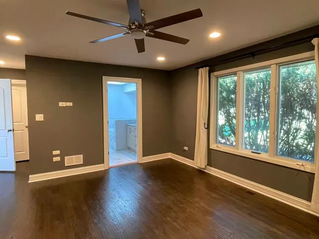 a view of a livingroom with wooden floor and a ceiling fan