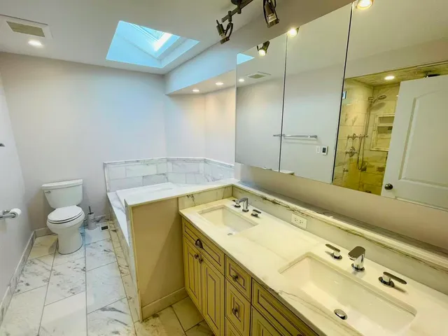 a bathroom with a sink mirror and toilet